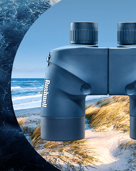 A pair of blue Bushnell binoculars is overlaid on a split background of ocean waves and a sandy beach with grass under a clear sky.