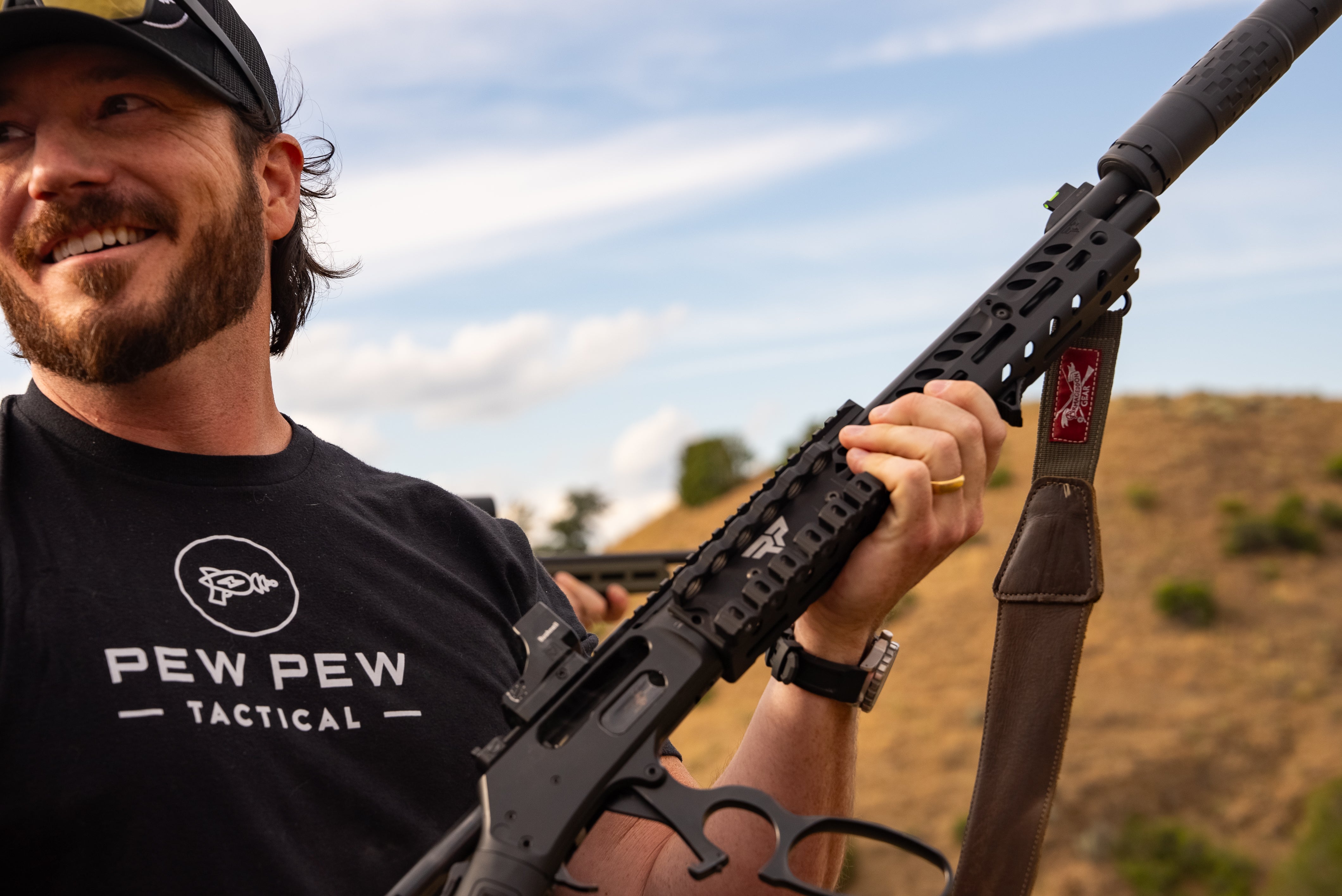 Man holding a rifle with a scenic background