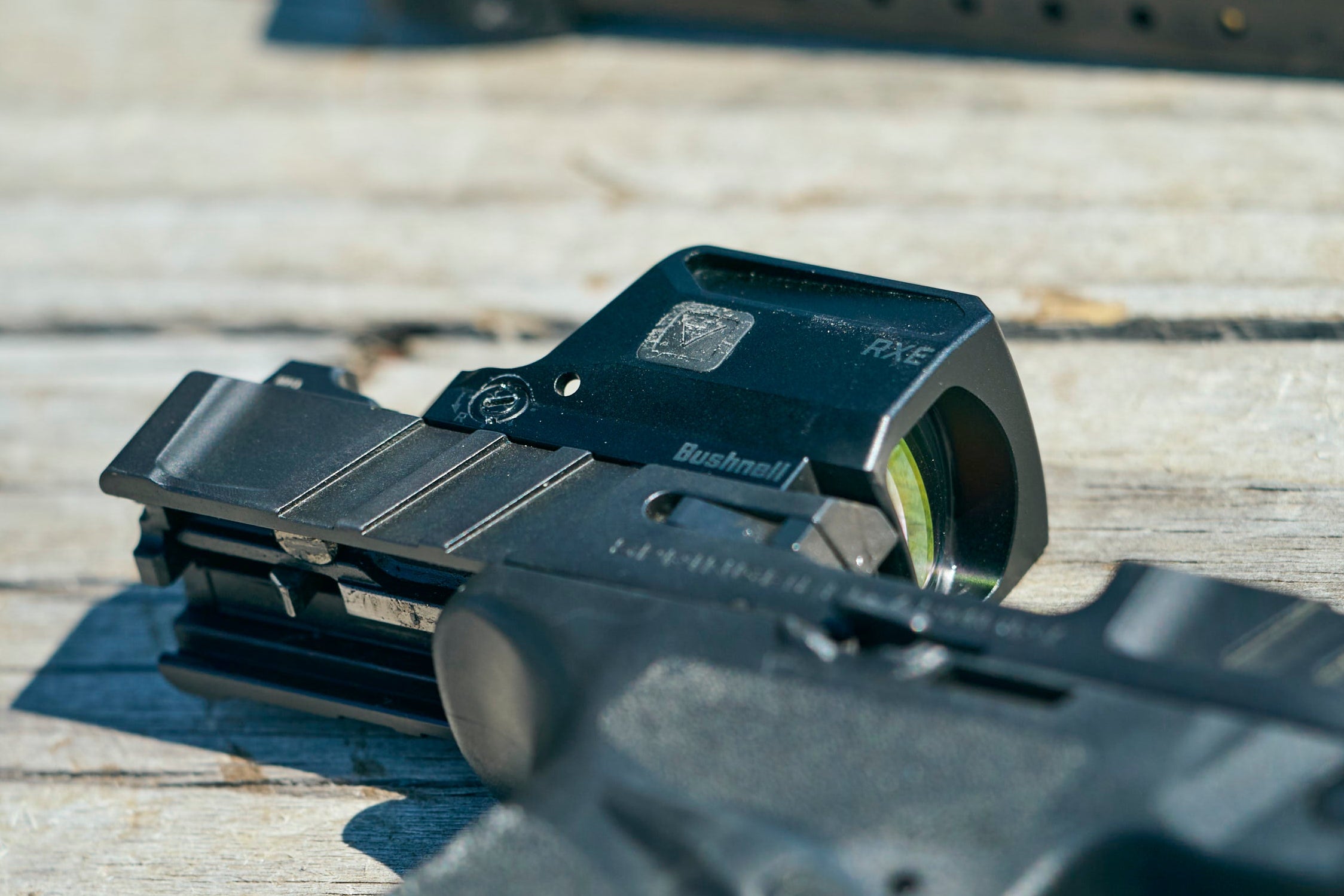 Close-up of a firearm with a sight on a wooden surface