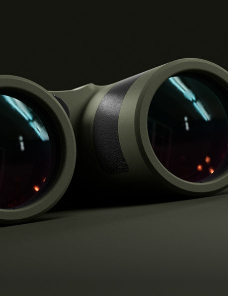 Close-up of the lenses of a pair of dark green binoculars, reflecting light and indoor surroundings, set against a dark background.