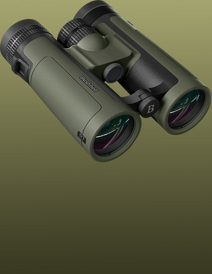 A pair of binoculars in olive green and black, shown floating against a solid olive green gradient background. The brand name 'Browning' is visible on the side of the left eyecube.