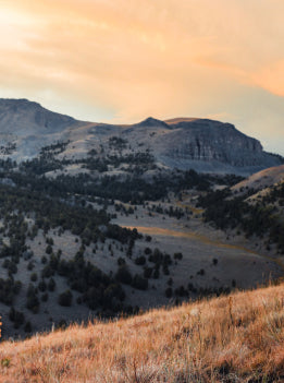 Mountain landscape with a sunset casting warm light over the terrain
