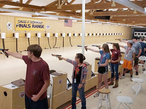 Young adults learning proper shooting at a range