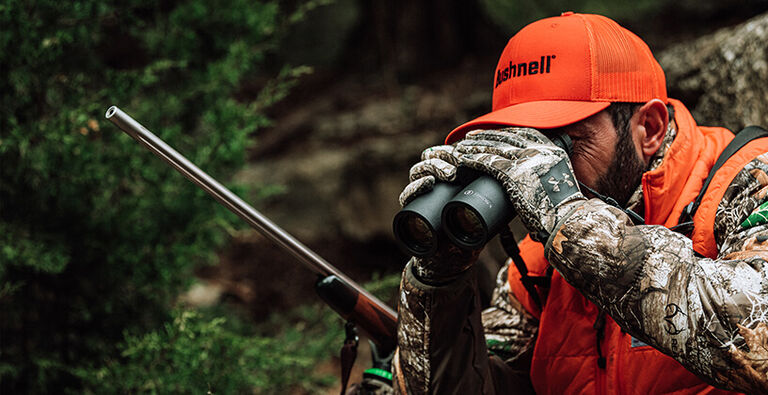 Hunter looking through Bushnell Binoculars