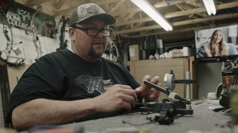 T-Bone Turner adjusting his bow gear at a workbench