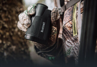 Close-up image of hunter holding Bushnell Prime 1800 Laser Rangefinder