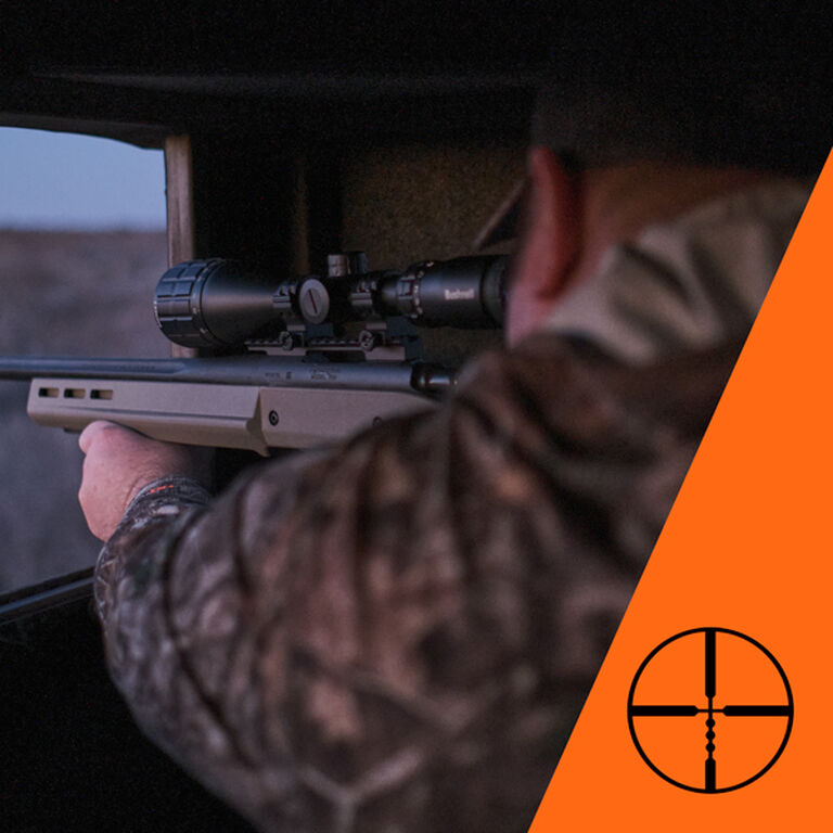 Hunter aiming through riflescope with ballistics drop compensation reticle