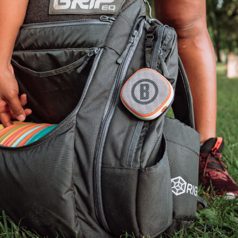 Disc Golfer with Disc Jockey Bluetooth Speaker attached to bag