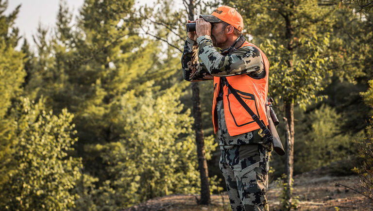 Hunter in a forest with Bushnell Engage DX Binoculars