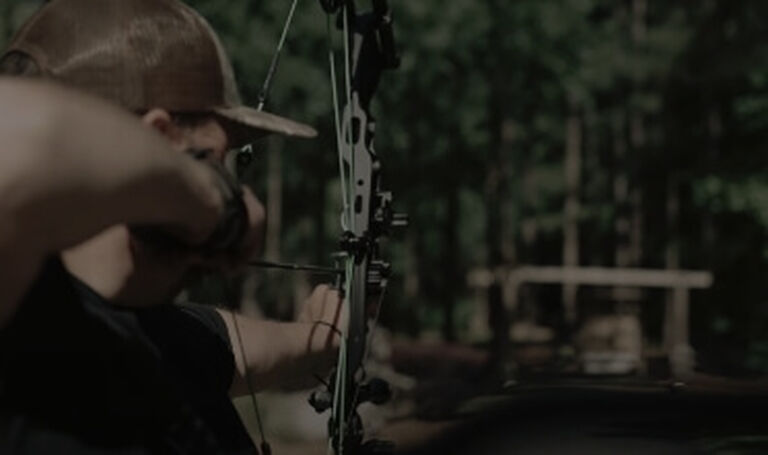 Bow hunter aiming at target
