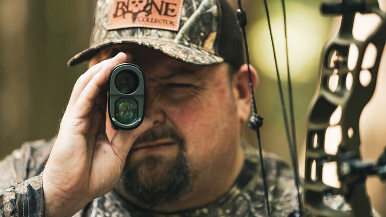 Travis T-Bone Turner looking through Bone Collector Laser Rangefinder