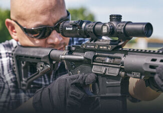 Target shooter aiming through AR Optics 1-8x24 Illuminated Riflescope