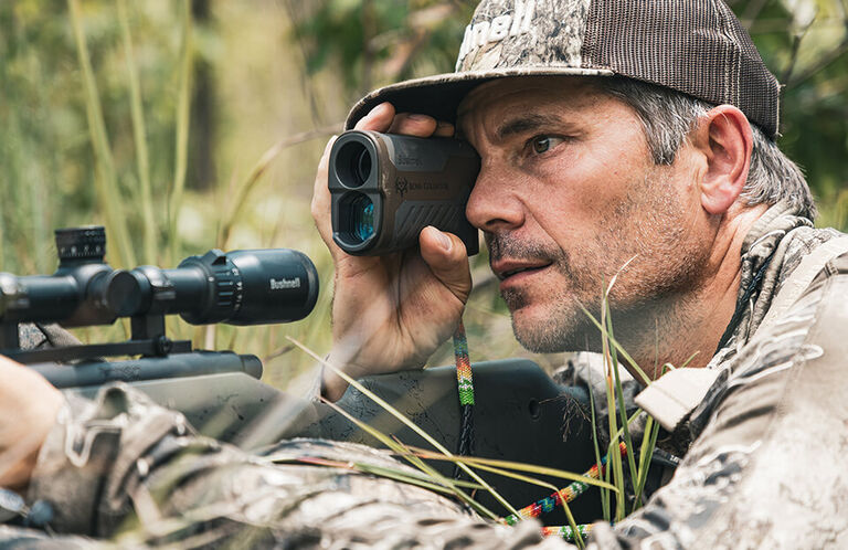 Bone Collector Nick Mundt looking through Bone Collector Laser Rangefinder