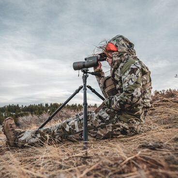 Man doing Using a Bushnell spotting scope