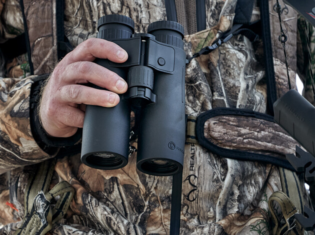 Close up detail of bow hunter holding Fusion X Rangefinding Binoculars